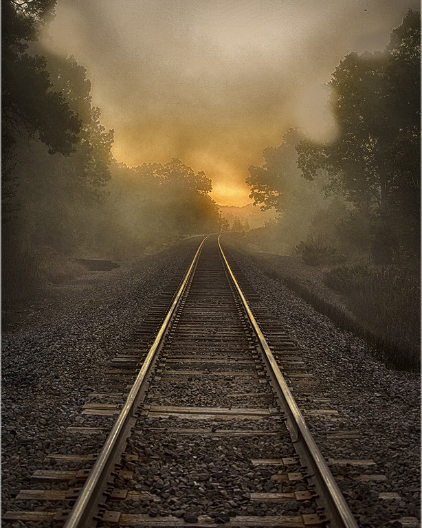 photo of the sunrise over railroad tracks